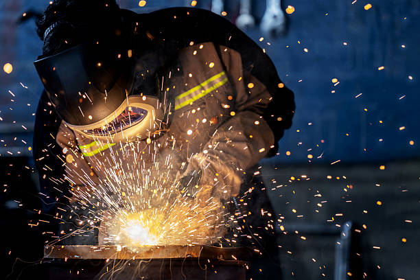 istock Experienced engineer wearing protective suit and welding helmet performs precision welding in an industrial factory. Sparks illuminate the workspace, showcasing occupational safety, technical skill, and heat-intensive metalwork in heavy industry. 2224716844