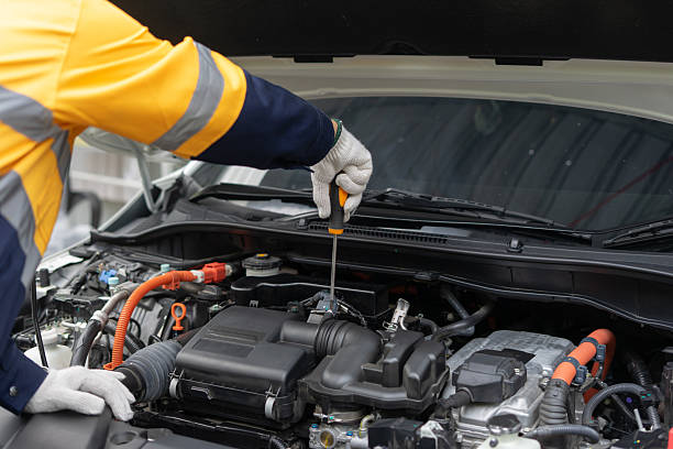 istock Mechanic in uniform inspects car engine with screwdriver 2224721096