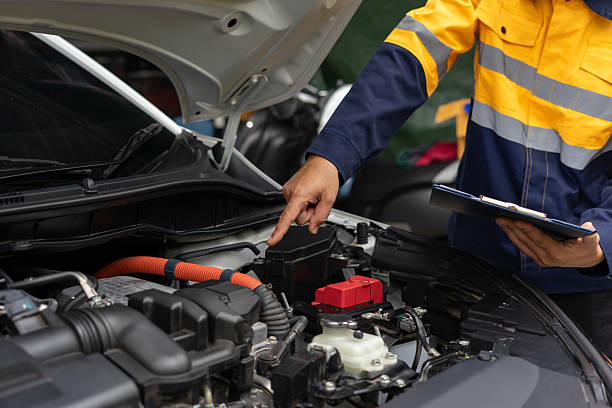 istock Mechanic inspects car engine with clipboard, focusing on details 2224721210