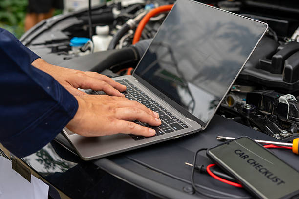 istock Mechanic using laptop for car diagnostics on open hood 2224721372