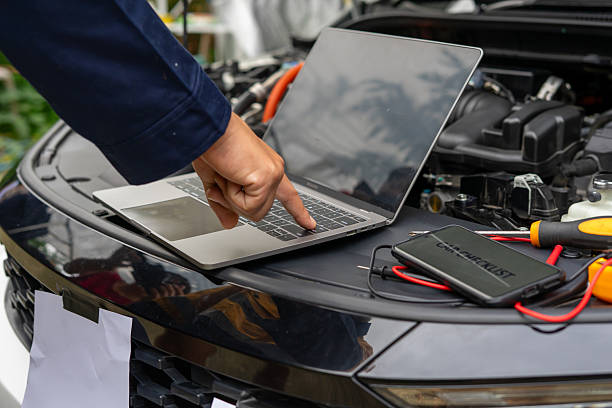 istock Person using laptop on car hood for diagnostics 2224721387