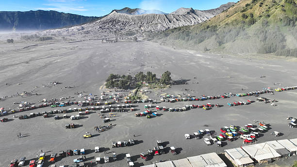 istock A panoramic view reveals a bustling gathering of jeeps and visitors on the ash-covered caldera, with Mount Bromo gently smoking in the background 2224723725