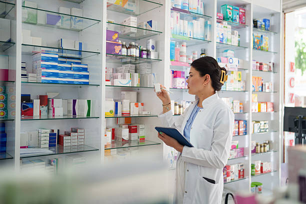 istock Young Female Pharmacist Organizing Shelves with Digital Tablet 2224737135