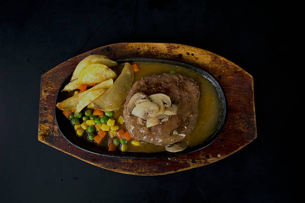 istock Beef steak with potatoes and vegetables, on wooden table 2224739113