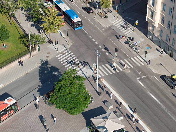 Aerial view of city streets with people on the move and buses on the road.