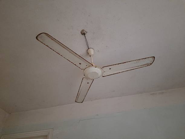 istock Old rusty white metal ceiling fan and white ceiling, old houses, architecture 2224745556