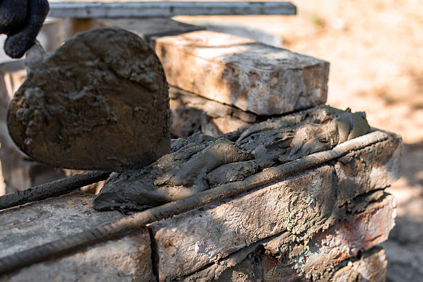 istock man applying mortar to brick structure with trowel, preparing for further construction 2224750606