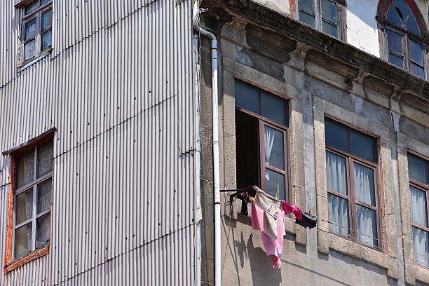 washed laundry, hung out to dry on a line between outside windows of an old apartment building in the historic downtown district of  Porto, Portugal