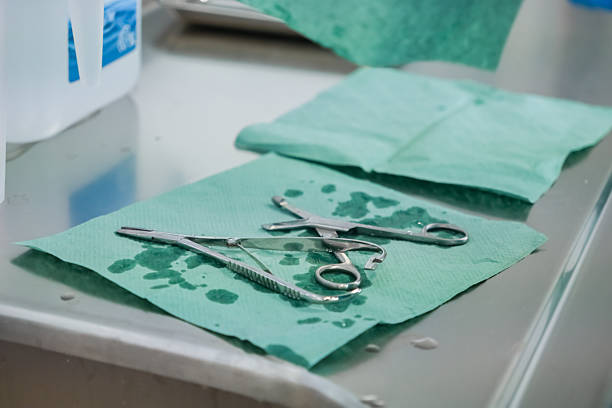istock Essential surgical instruments lay on wet green medical drapes on a metallic table, signifying preparation and strict hygiene in a healthcare setting 2224754023
