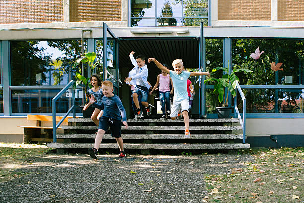 istock a group of elementary school students runs out of school for recess 2224758298