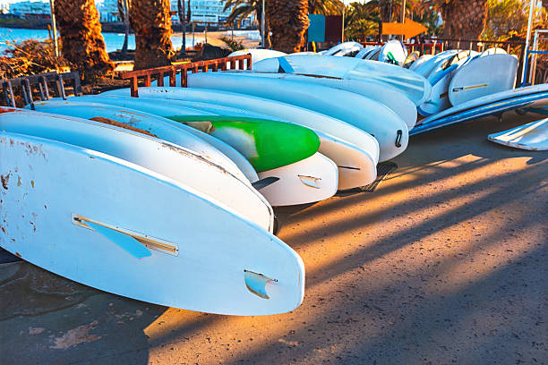 A quiet stand of surfboards leads toward the iconic Waikiki Waves.