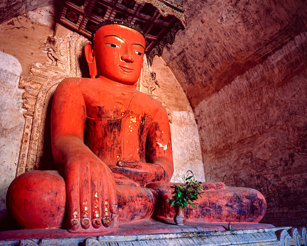 A red-colored Buddha image inside Sulamani Temple in Bagan, Myanmar, noted for its vivid hue and serene expression.