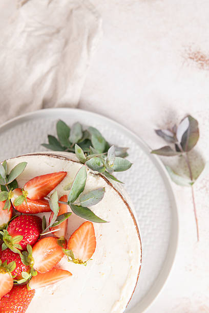 istock Close-up view highlighting fresh strawberries and decorative eucalyptus atop a beautifully frosted cake, perfect for sweet food visuals 2224762783