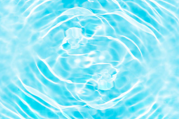 istock Blue water with ripples on the surface. Defocus blurred transparent blue colored clear calm water surface texture with splashes and bubbles. Water waves with shining pattern texture background. 2224766497
