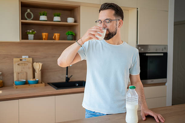 istock Bearded man drinking glass of milk in modern kitchen 2224769140
