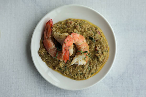 Authentic Brazilian shrimp stew known as Bobó de Camarão served in a rustic black clay pot on a wooden board. Perfect for culinary content, South American cuisine features, recipe illustrations, and food blogs.