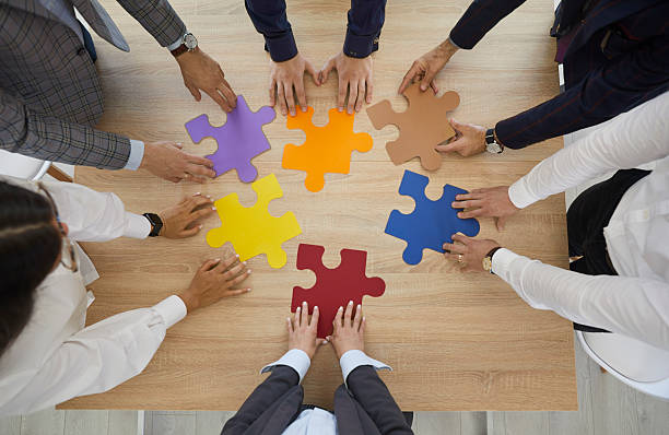 istock Employees connect jigsaw puzzles involved in teambuilding 2224775473