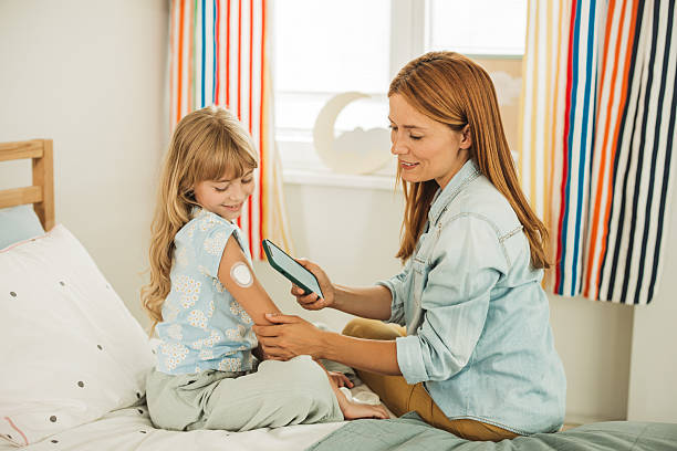 istock Mother checking glucose level on daughter's glucose meter 2224777456