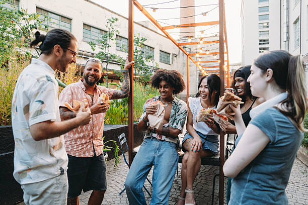 istock Group of friends eating pizza outdoors at a restaurant 2224782747