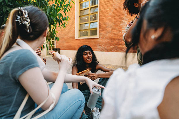istock Group of young friends eating pizza outdoors and chatting 2224782748