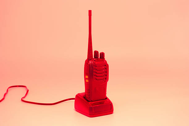 istock Bright red walkie talkie resting on its charger against a plain backdrop, showcasing a vintage design and emphasizing retro communication devices 2224789845