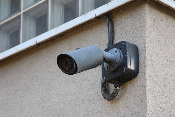 istock Black security camera mounted on light colored building wall providing surveillance and monitoring capabilities 2224791064