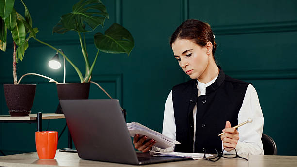 istock Stylish young woman working on a laptop in a modern office. 2224791869