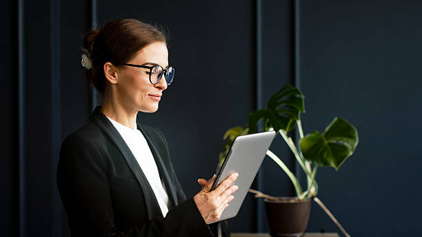 istock Focused middle-aged businesswoman working with a tablet in a modern office. 2224791902