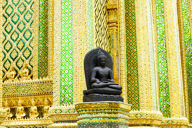 A tranquil Buddha statue sits elegantly within a richly decorated temple, showcasing intricate gold and vibrant designs that reflect cultural heritage and spirituality.