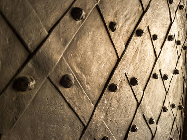 Old metallic door with decorative iron studs and diagonal pattern, close-up.