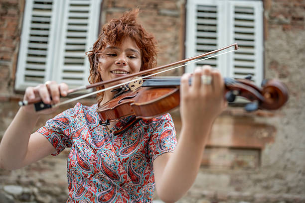 istock Young Woman Playing Violin Outdoors with a Cheerful Expression 2224802370