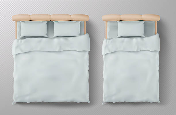 Top view bed mockup with white bedding Top view bed mockup with white bedding. Realistic 3d beige headboard, pillows and blanket from above on transparent background for interior design, furniture catalog or bedroom decoration concept. bed frame stock illustrations