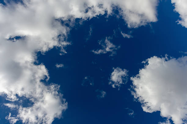 istock Bright clouds drift across a clear blue sky during midday 2224804055
