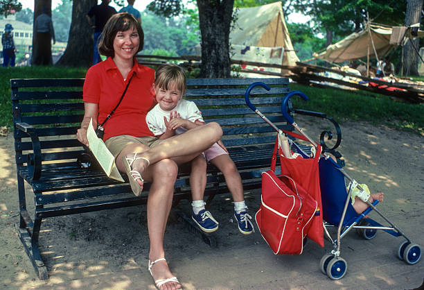 A Beautiful young mother with her daughter in jogging stroller outside in autumn nature