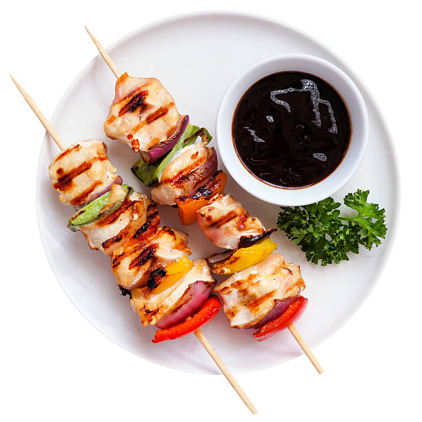 istock BBQ chicken skewers with grilled vegetables on a white plate isolated on white 2224807100