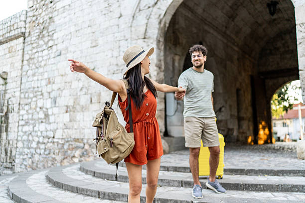 istock Happy tourist couple holding hands while sightseeing old town 2224809579