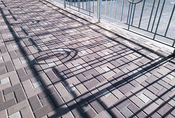 shadow of a metal fence nailed to the granite tiles