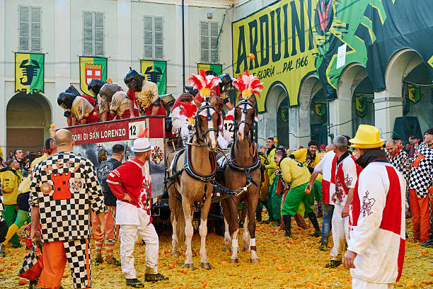 Ivrea, Italy - March 02, 2025: groups in traditional dressing take part in the Battle of the Oranges, where a teams of orange handlers on foot throw oranges (representing old weapons and stones) against aranceri of the team \