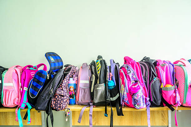 istock Colorful school backpacks resting on wooden bench in classroom 2224810120