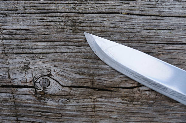 Knife on the old wooden background. Focus on the knife.