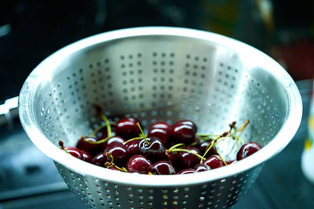 istock red cherries lie in a colander in the kitchen 2224812065
