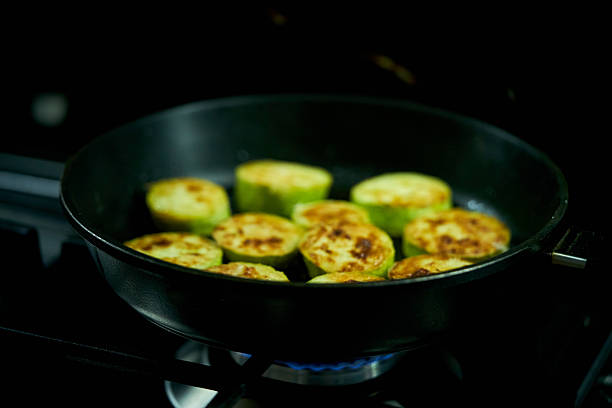 zucchini are fried in a frying pan in the kitchen