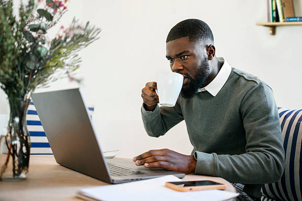 istock Young African entrepreneur working on laptop and drinking coffee at cafe 2224817059