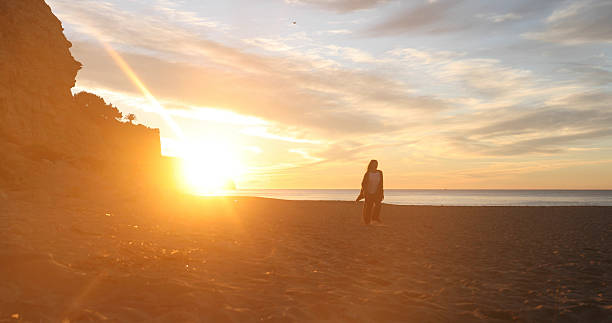 Young woman explores empty beach at sunrise, Lagos