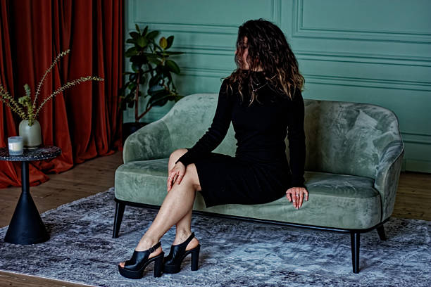 istock Young woman sitting on the green sofa 2224831955
