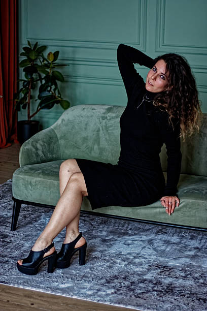 istock Young woman sitting on the green sofa 2224832534