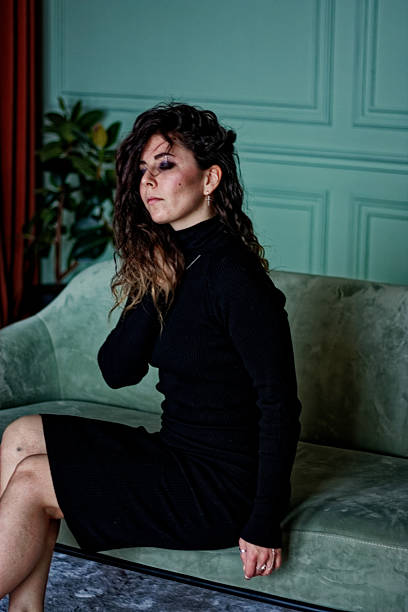 istock Young woman sitting on the green sofa 2224832543