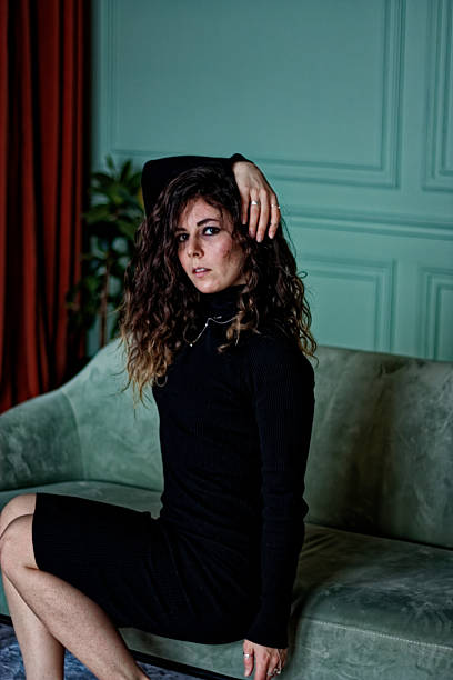 istock Young woman sitting on the green sofa 2224832548