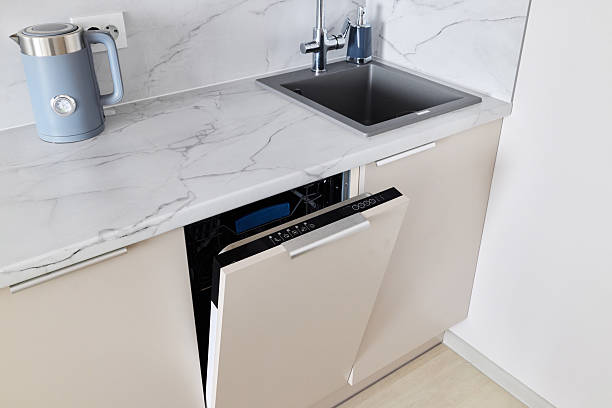 Modern, stylish kitchen featuring a dishwasher and a sink elegantly placed on a marble countertop