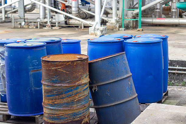istock A collection of used blue barrels with some rust, outdoors, at an industrial processing plant. 2224843480